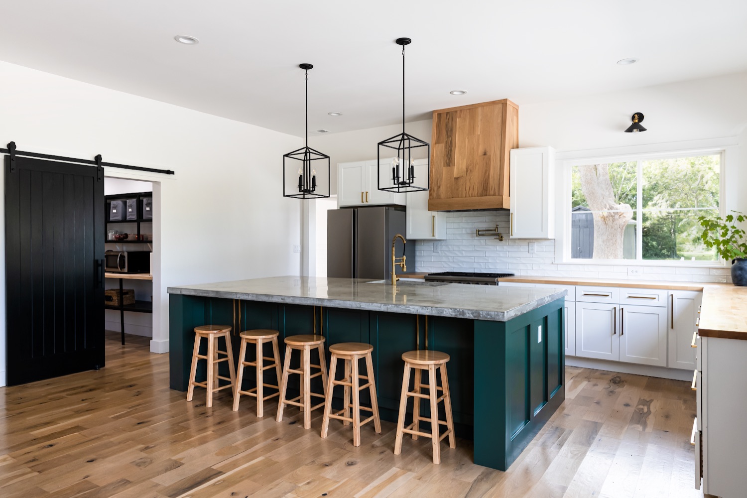 Kitchen view toward a black sliding barn door